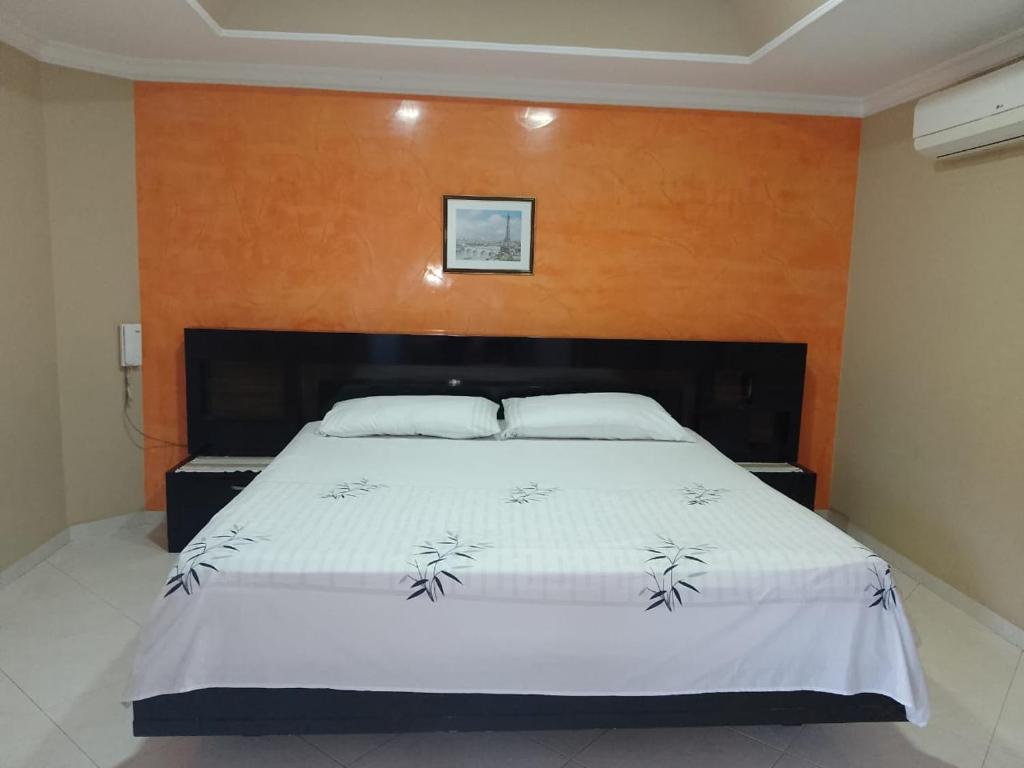 1 dormitorio con 1 cama grande y cabecero de madera en Apartamento duplex Buganaviles, en Neiva
