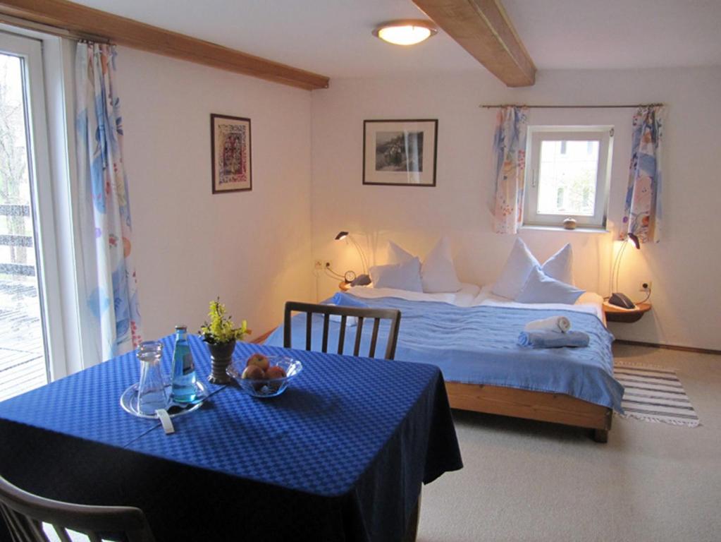 a bedroom with a bed and a table with a blue table cloth at Landgasthaus Schwarzbachtal in Lohsdorf