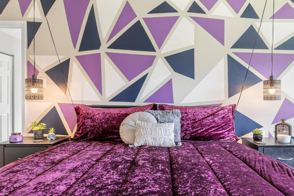 ein violettes Bett mit einer lila und weißen Wand in der Unterkunft The Safari House: Where Adventure & Comfort Awaits in Richmond
