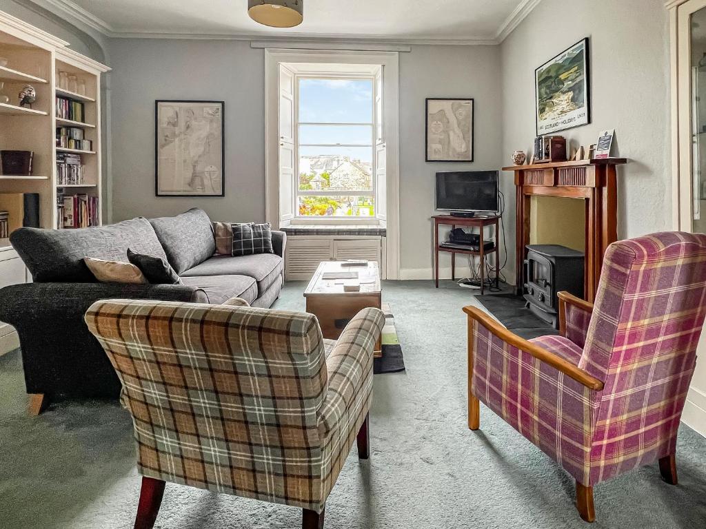 a living room with a couch and two chairs at Cochrane House in Kirkcudbright