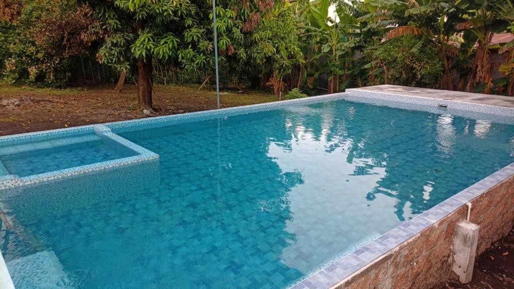 een groot zwembad met blauw water bij Hotel Chulamar, Piscina y Restaurante in Escuintla