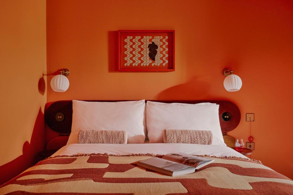 ein Schlafzimmer mit einem Bett mit einem Buch darauf in der Unterkunft Ember Locke Kensington in London