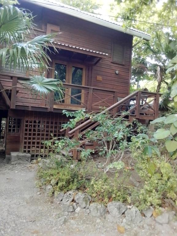 a log cabin with a porch and a deck at Cocolobo Resort in West End