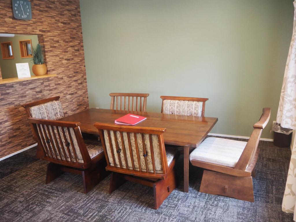 una mesa de madera con sillas y un libro sobre ella en CANAL HOUSE BOSTONS, en Niigata