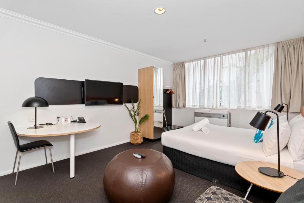 a hotel room with a bed and a desk at Murray Street Urban Retreat City Studio in Perth