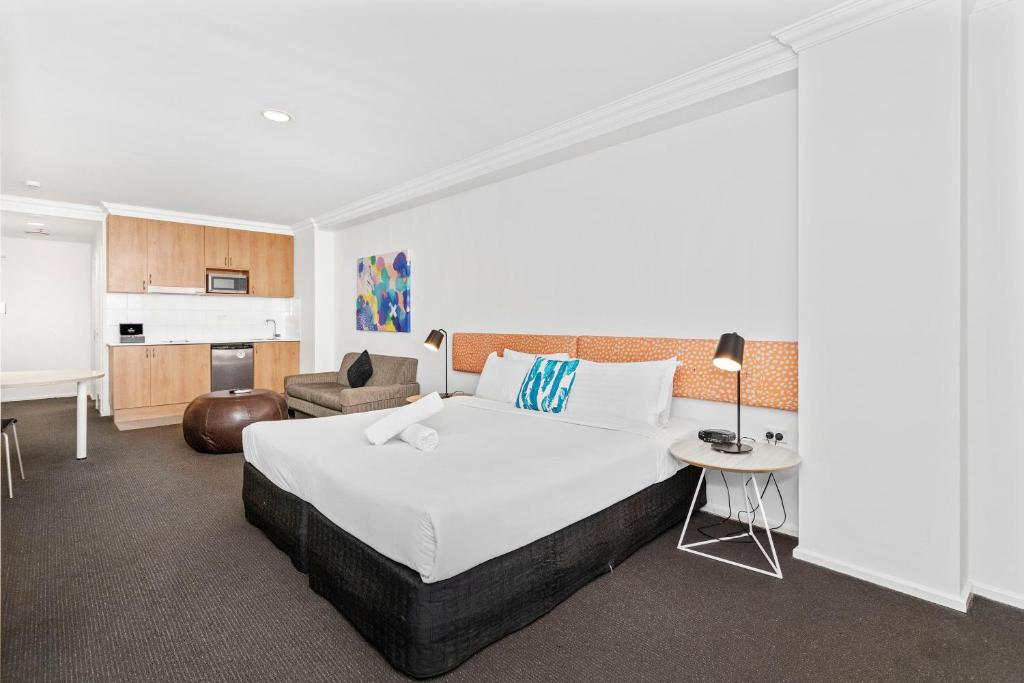 a hotel room with a large bed and a chair at Perth Cbd Oasis Murray Street Studio in Perth