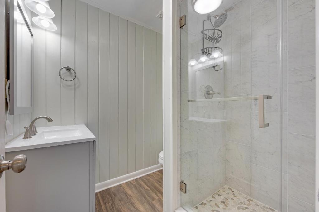 ein weißes Badezimmer mit Dusche und Waschbecken in der Unterkunft Beachy Keen, North Myrtle Beach beach single-family house, 150 feet to ocean! Pets welcome! in Myrtle Beach