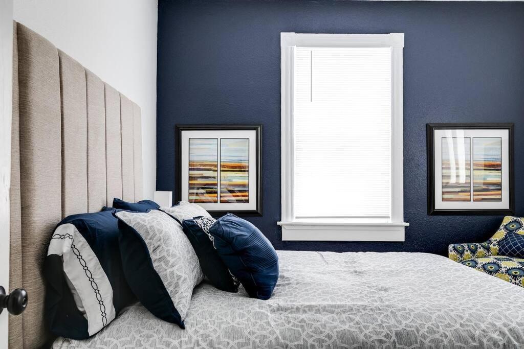 a bedroom with a bed with blue walls and windows at Chic Urban Couples Retreat: Perfect Getaway 'n RVA in Richmond