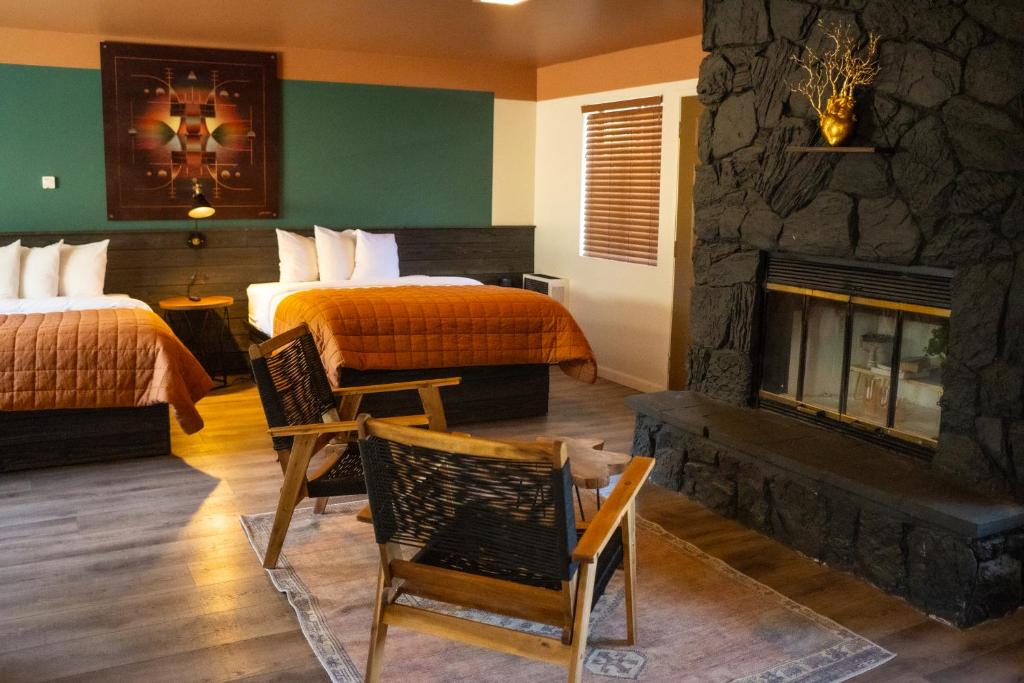 Sessions Retreat & Hotel في بيغ بير لاكي: غرفة فندقية بسريرين وموقد