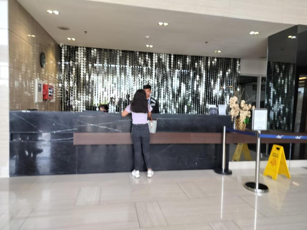 a woman standing in front of a counter in a building at Wind Residences Apt. 1506 Tagaytay in Tagaytay