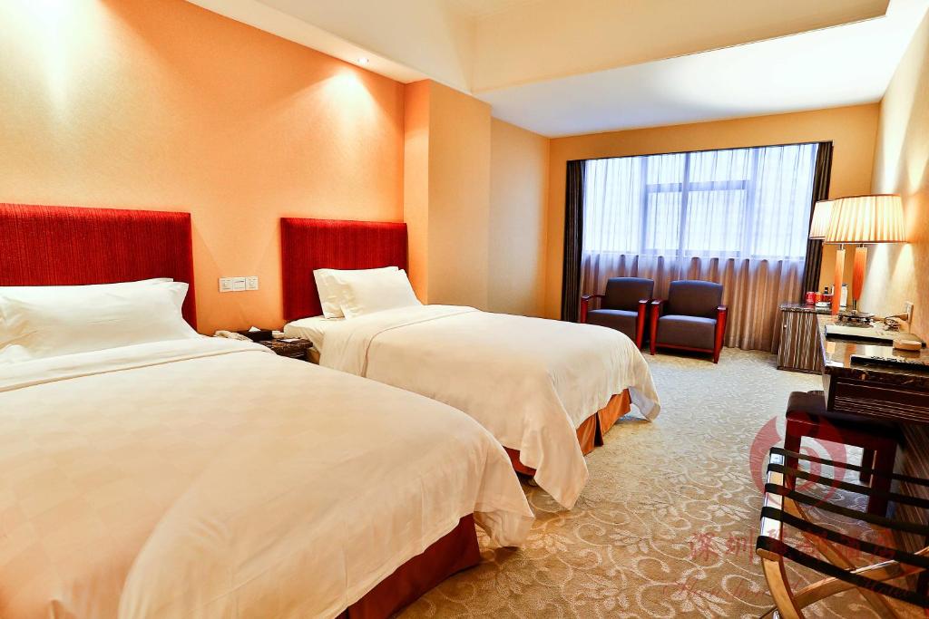 Habitación de hotel con 2 camas y ventana en Shenzhen Lido Hotel, en Shenzhen
