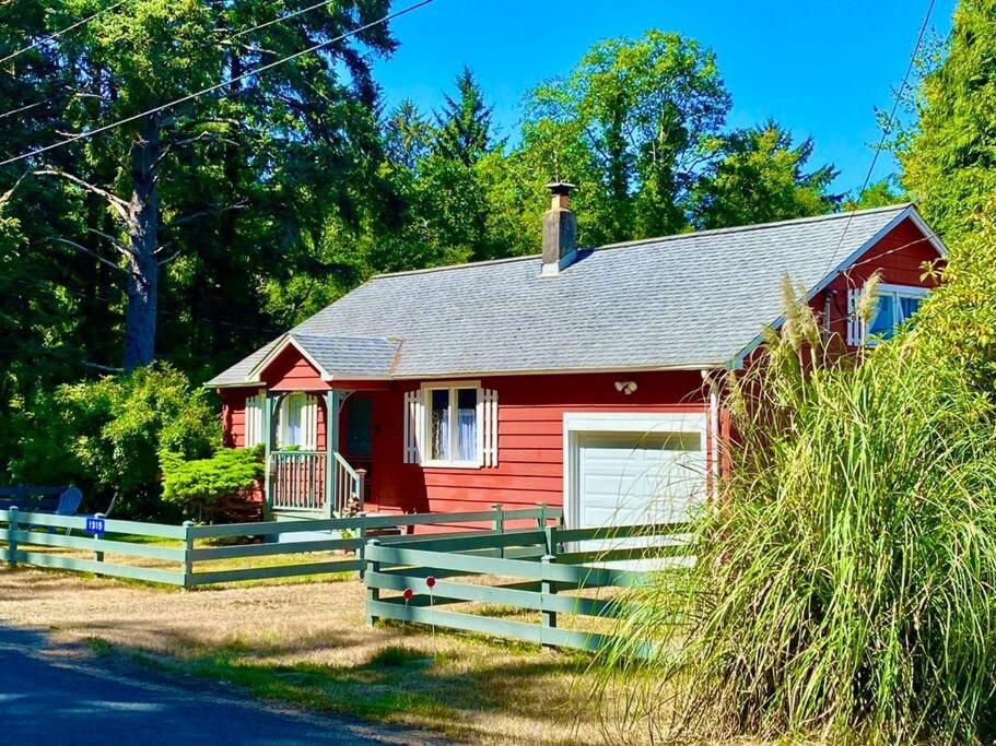 una casa rossa con una recinzione di fronte di Ocean Park Beach Cottage a Ocean Park