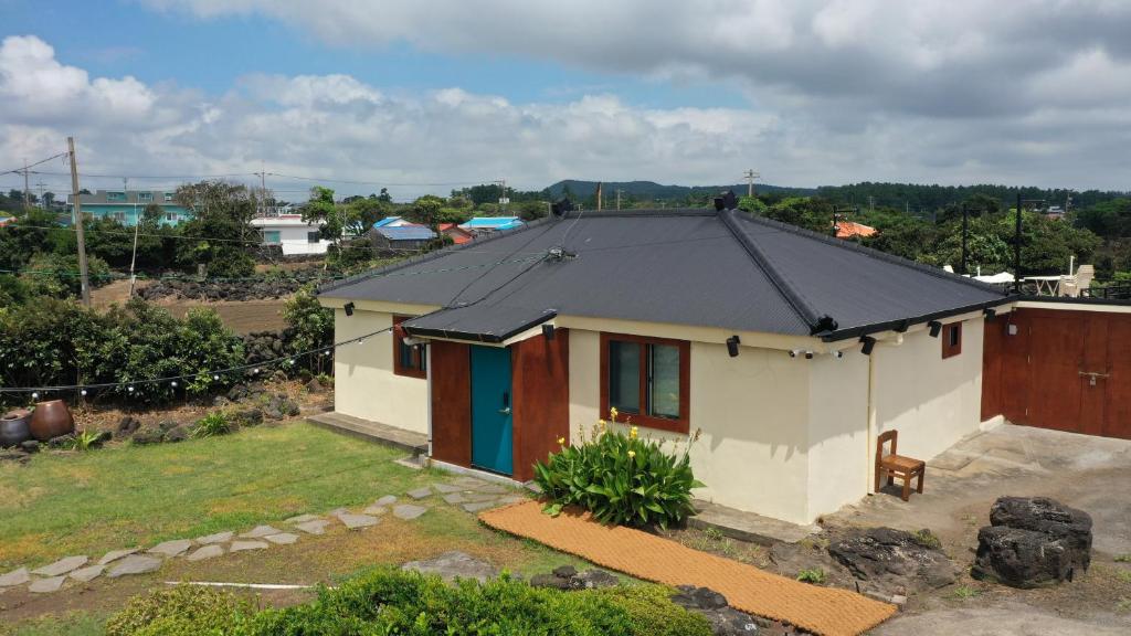 a small white house with a black roof at SamDalChae in Seogwipo