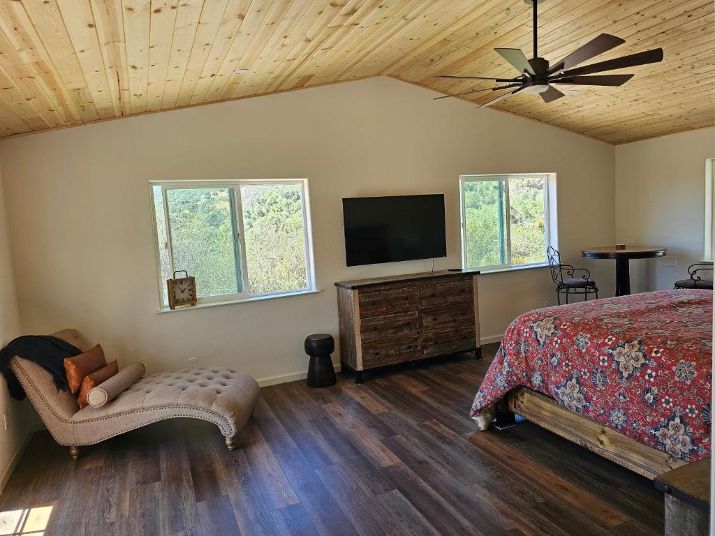 a bedroom with a bed and a flat screen tv at Hidden Falls Retreat in Oakhurst