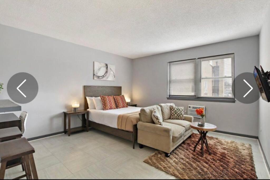 um quarto com uma cama, uma cadeira e uma janela em Modern NorthSide Studio Gem em Chicago