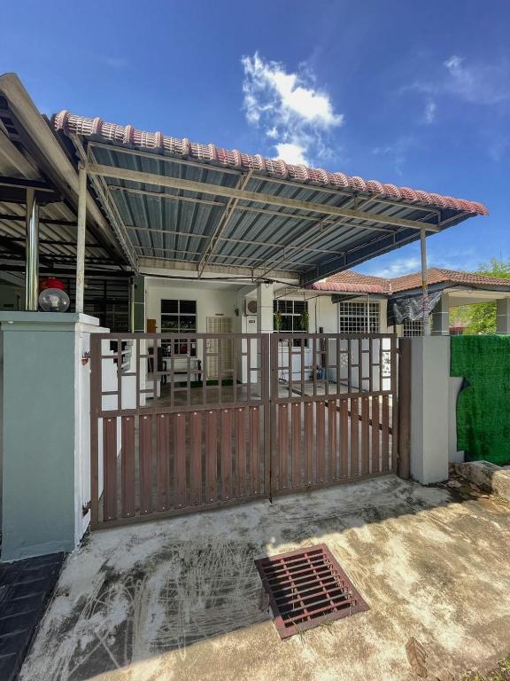 una puerta de madera a una casa con una valla de madera en Nurjah Homestay, en Kuala Terengganu