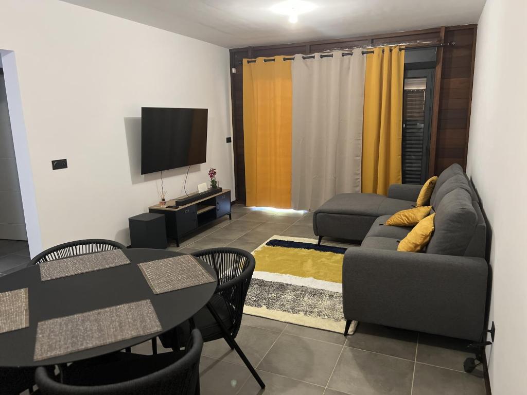 Μια τηλεόραση ή/και κέντρο ψυχαγωγίας στο APPARTEMENT T3 COSY et PAISIBLE avec JARDIN à REMIRE-MONTJOLY