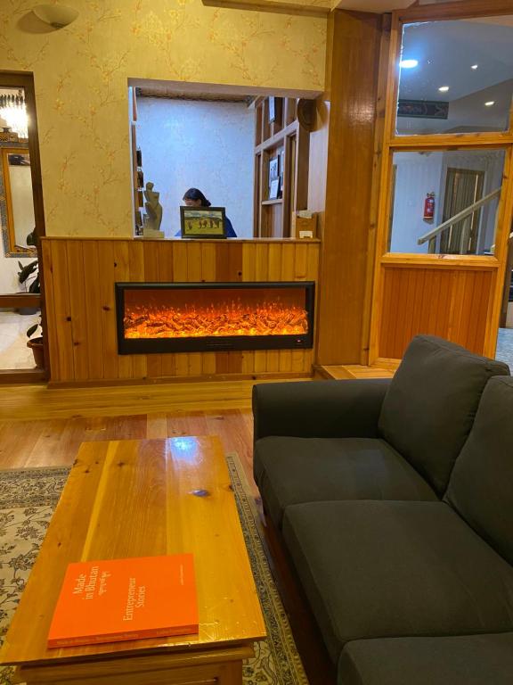 a living room with a couch and a fire place at Lhayhuel Resort and Spa in Paro