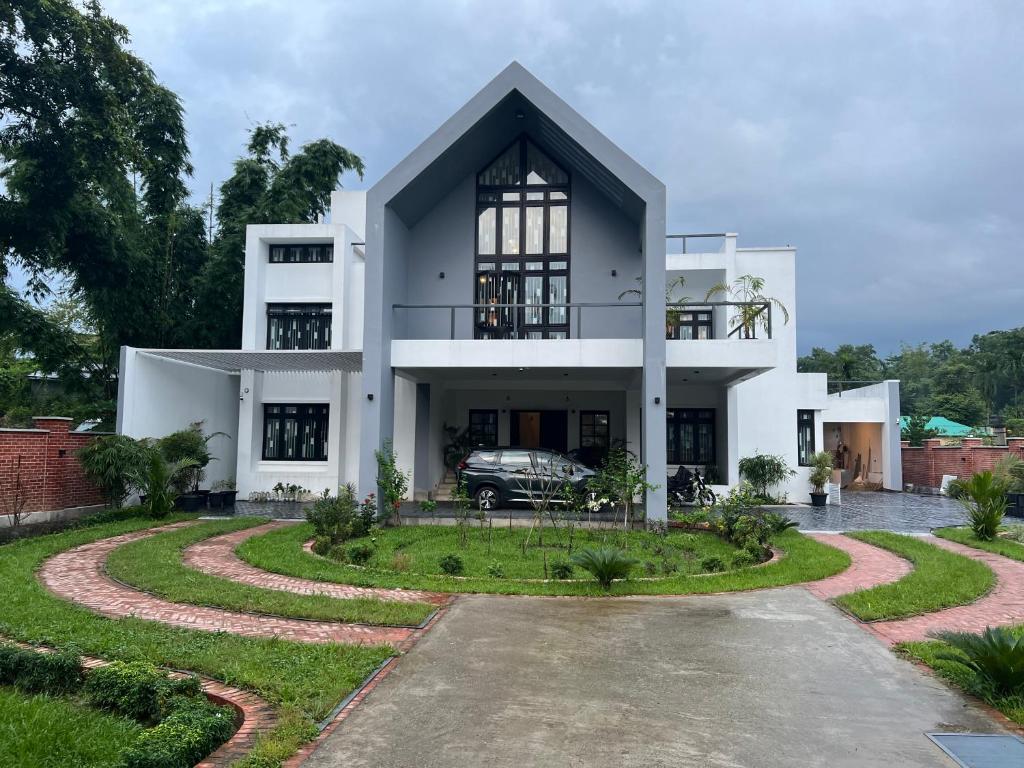 una casa blanca con un coche aparcado en la entrada en Yahiya en Sylhet