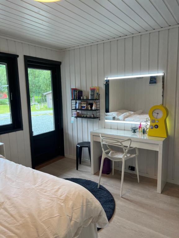 a bedroom with a bed and a desk and a mirror at Lykkja - Beautiful Waterfront House in Viggja