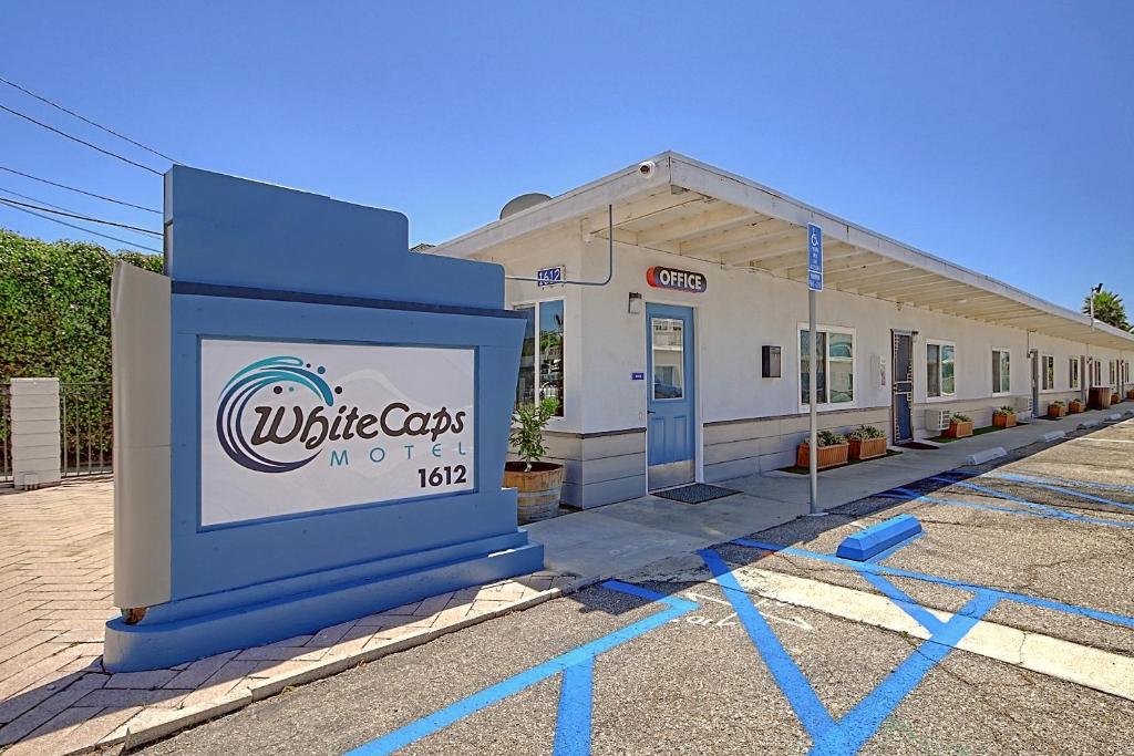 a building with a sign in front of it at White Caps Motel in Ventura