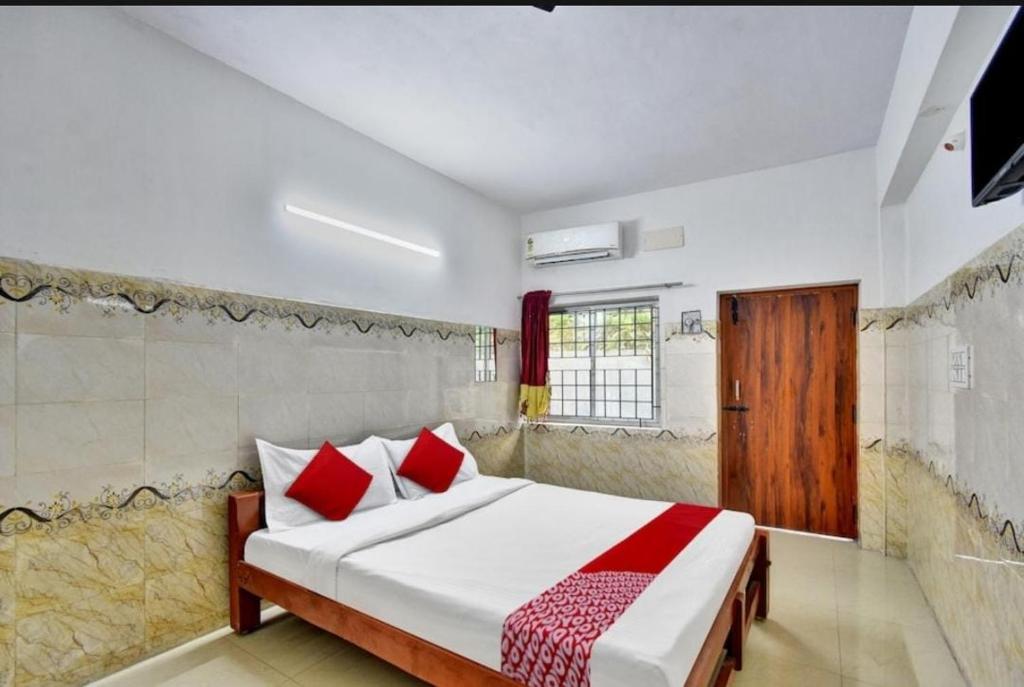 a bedroom with a large bed with red pillows at RK RESIDENCY INN in Chennai
