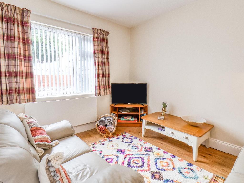 a living room with a couch and a tv at Richmond Cottage in Saltburn-by-the-Sea