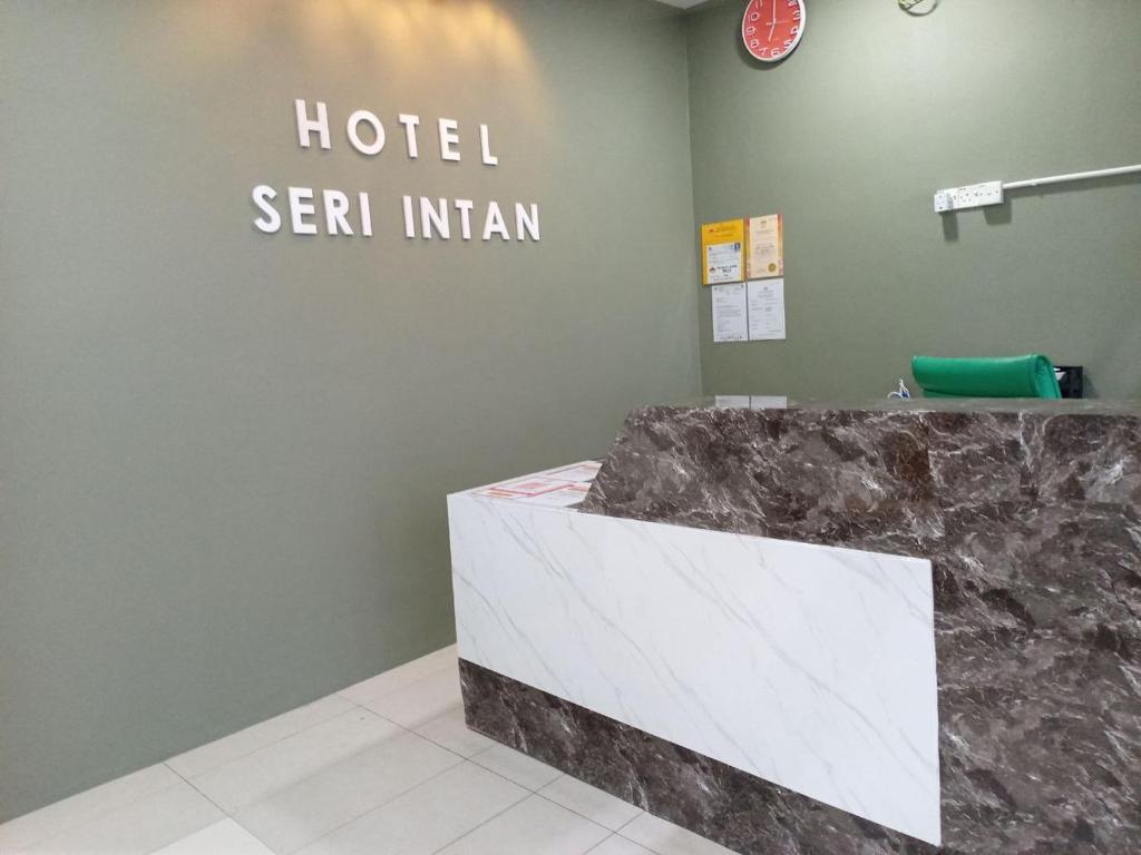 a hotel reception desk in a room with a hotel sign at Hotel Seri Intan Tampin in Tampin