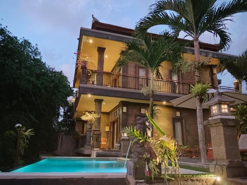 a house with a swimming pool in front of it at Ketut Kasta Guest House in Ubud