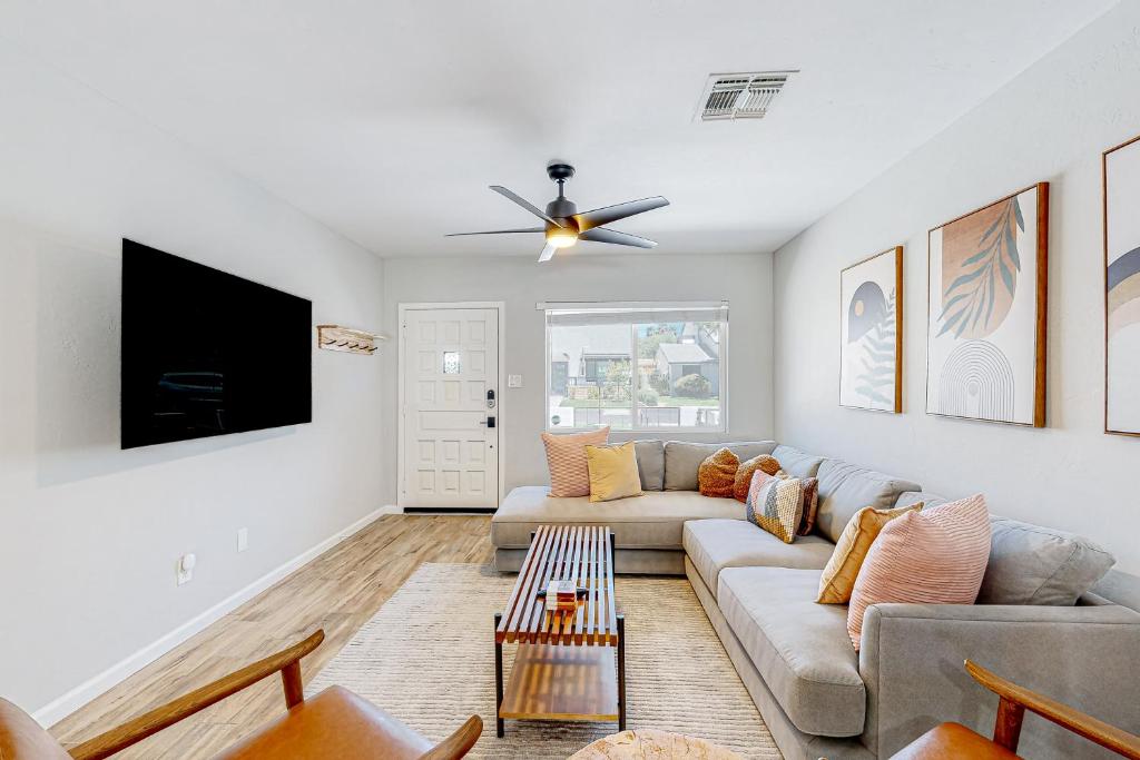uma sala de estar com um sofá e uma televisão de ecrã plano em Pink Door Place em Phoenix