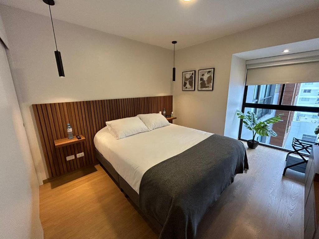 1 dormitorio con cama grande y ventana grande en Stylist and modern 1BR in Lima, en Lima