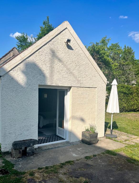 un garage avec une porte ouverte et un parasol dans l'établissement Studio avec grand jardin + parking, à Seraincourt