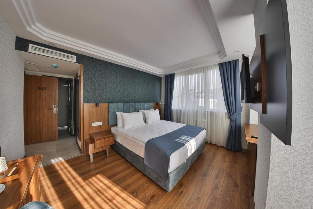 アンカラにあるBUKAVİYYE HOTELのベッドとテレビが備わるホテルルームです。