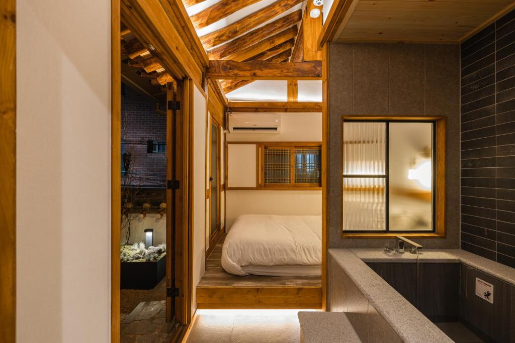 a bedroom with a bed and a mirror and a tub at Luxury hanok with private bathtub - SN05 in Seoul