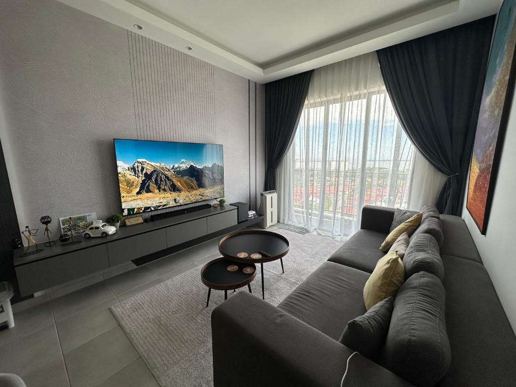 a living room with a couch and a flat screen tv at Sandakan SeaView-Suite Top Floor in Sandakan