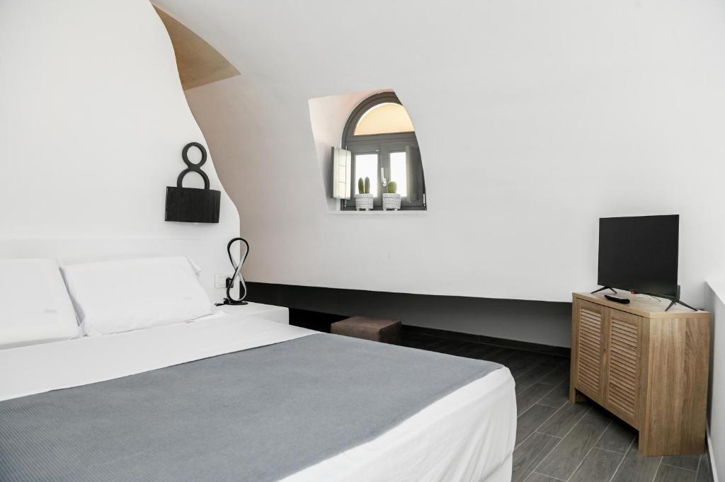una camera con letto e TV su un armadio di Villa Eleana a Monolithos
