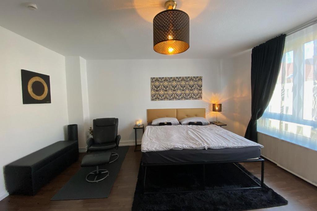 1 dormitorio con 1 cama y 1 silla en Private Apartment, en Hannover