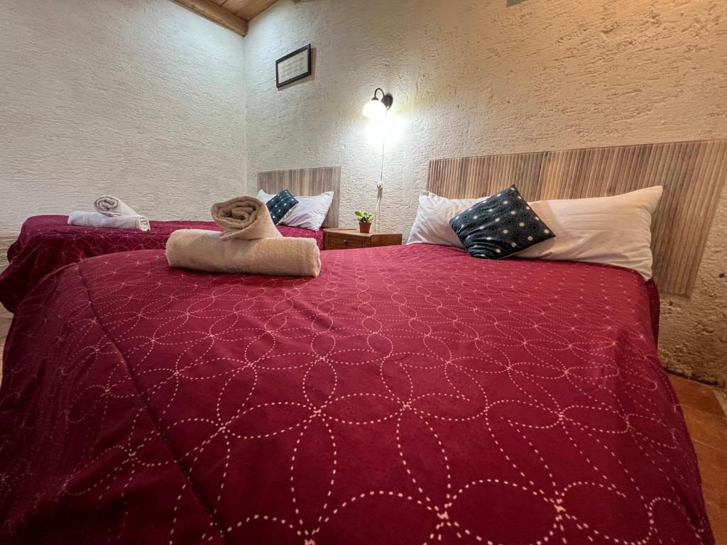 a bedroom with a large red bed with pillows at Casa del viajero colonial in Antigua Guatemala