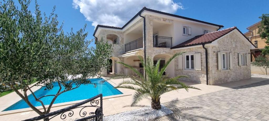 uma villa com piscina em frente a uma casa em Villa Martina em Pinezici