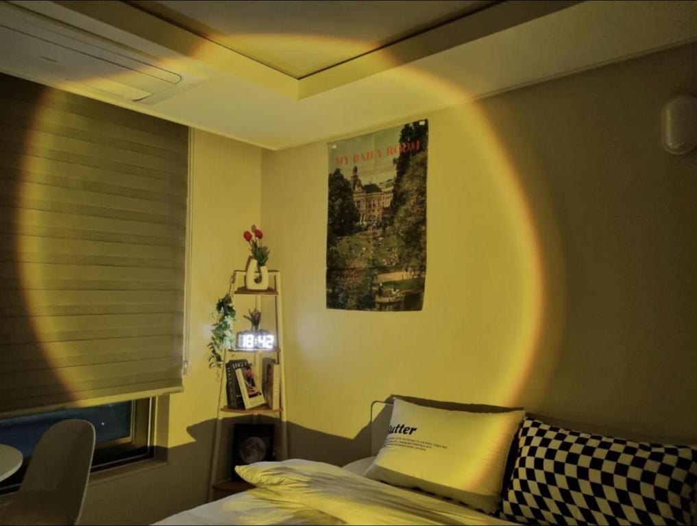 1 dormitorio con 1 cama y una foto en la pared en DAON STAR BnB j6, en Daegu