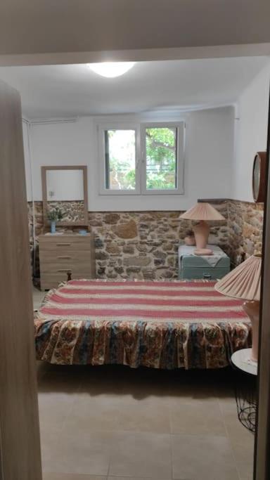 a bedroom with a bed and a stone wall at Ανακαινισμένο Διαμέρισμα in Chios