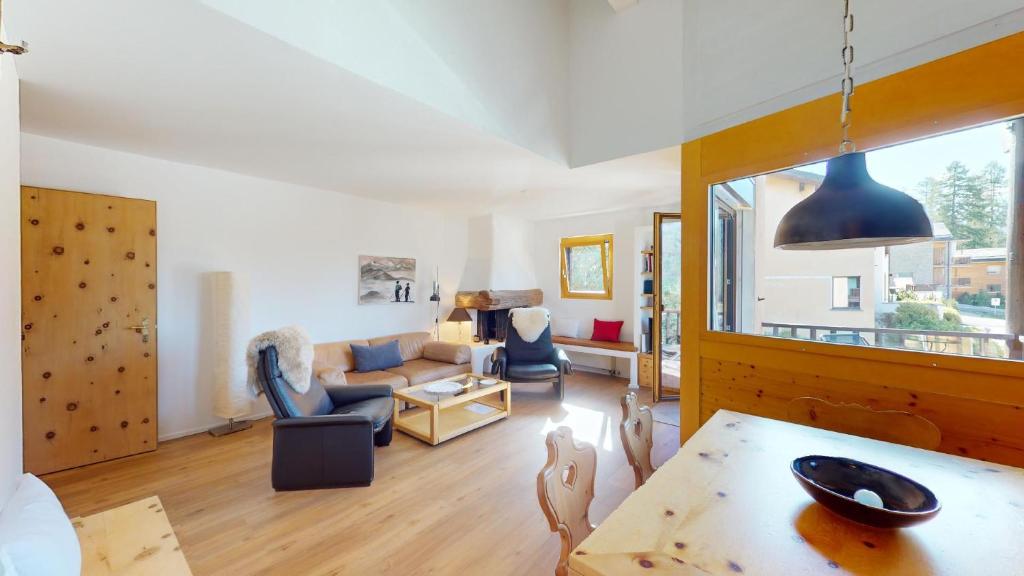 uma sala de estar com um sofá e uma mesa em Ers 52 em Pontresina