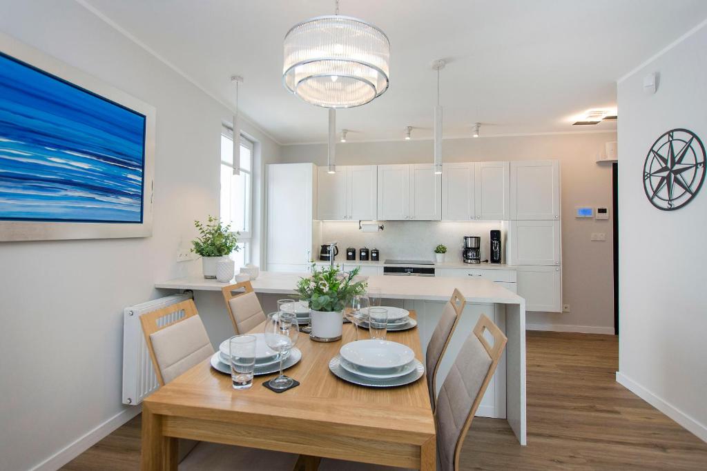 eine Küche und ein Esszimmer mit Tisch und Stühlen in der Unterkunft Villa Neptun - Exclusive Apartments in Danzig