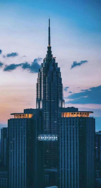 常州常州万景酒店的一座高大的建筑,上面有天线