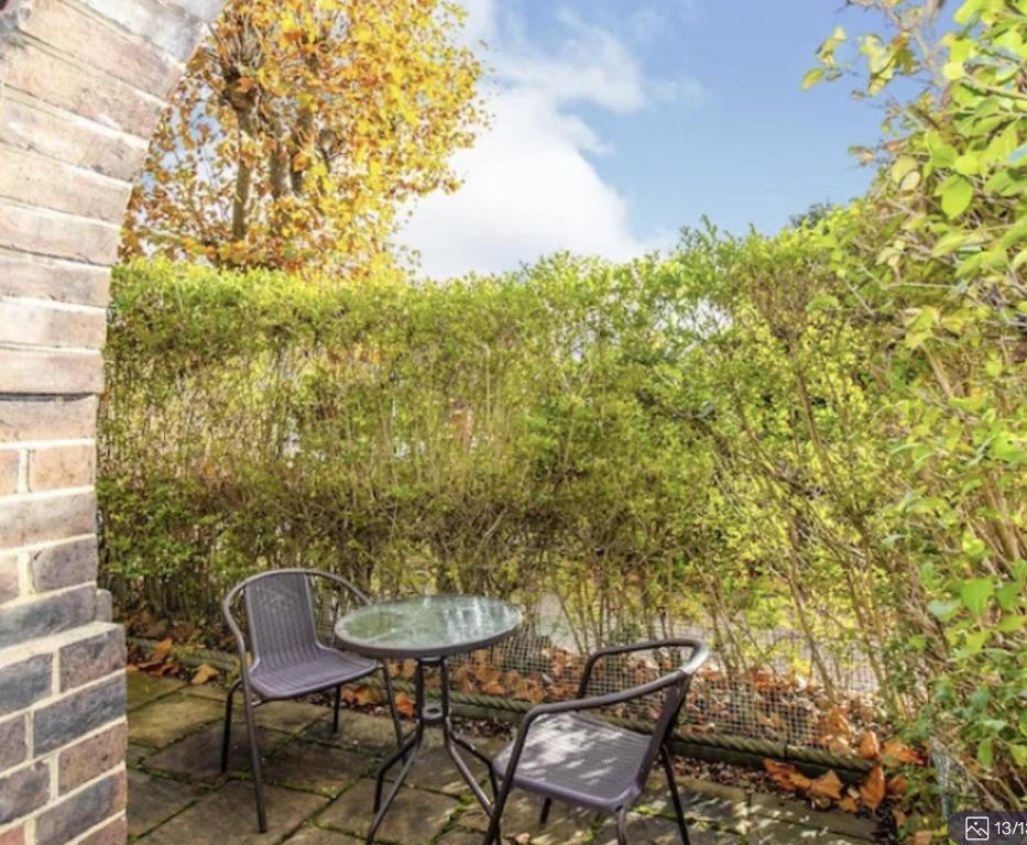 a patio with two chairs and a table at Wulfstan House Quiet, Neat, Comfy - 2 min to Central line, Westfield, Notting hill in London