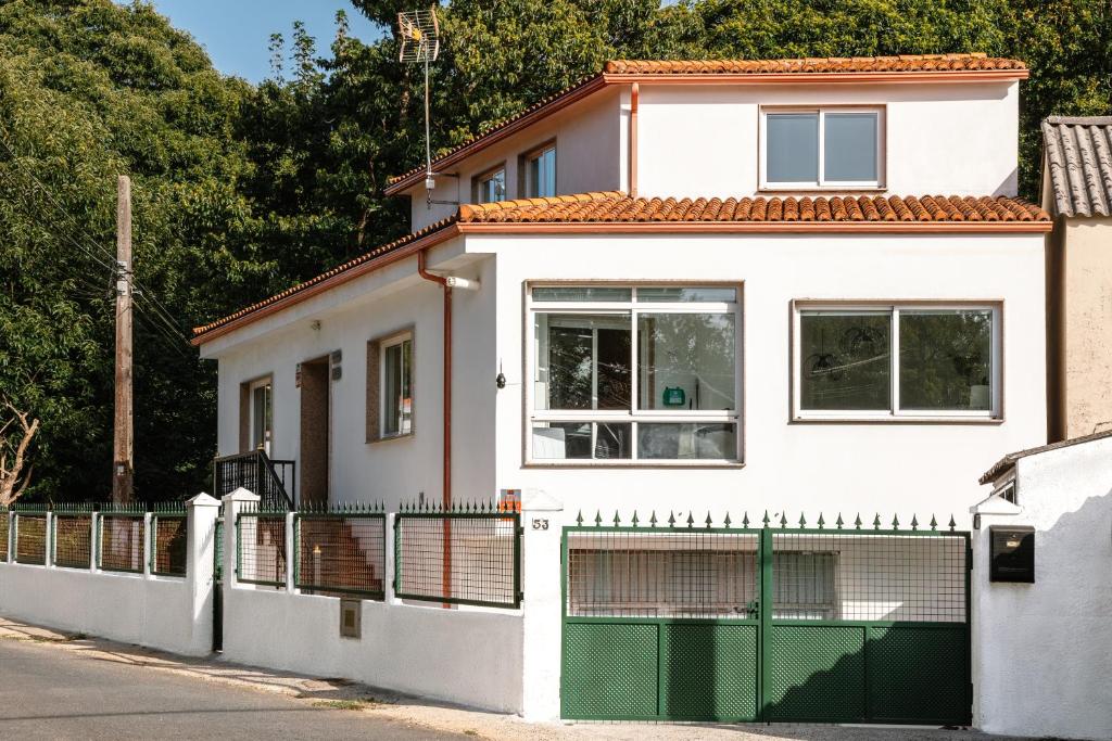 a white house with a green fence at Casa Bella Lalin- 4 Double bedroom Galician Country Home! in Pontevedra
