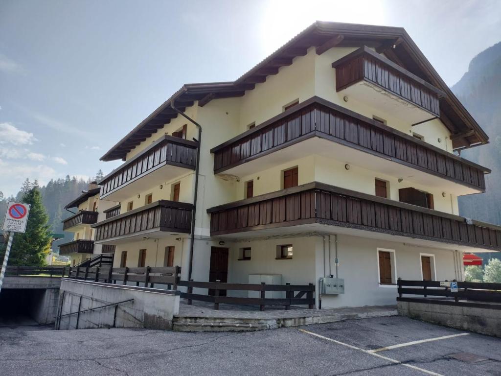 a large building with wooden balconies in a parking lot at Appartamento di Giulio & Giorgia in Predazzo