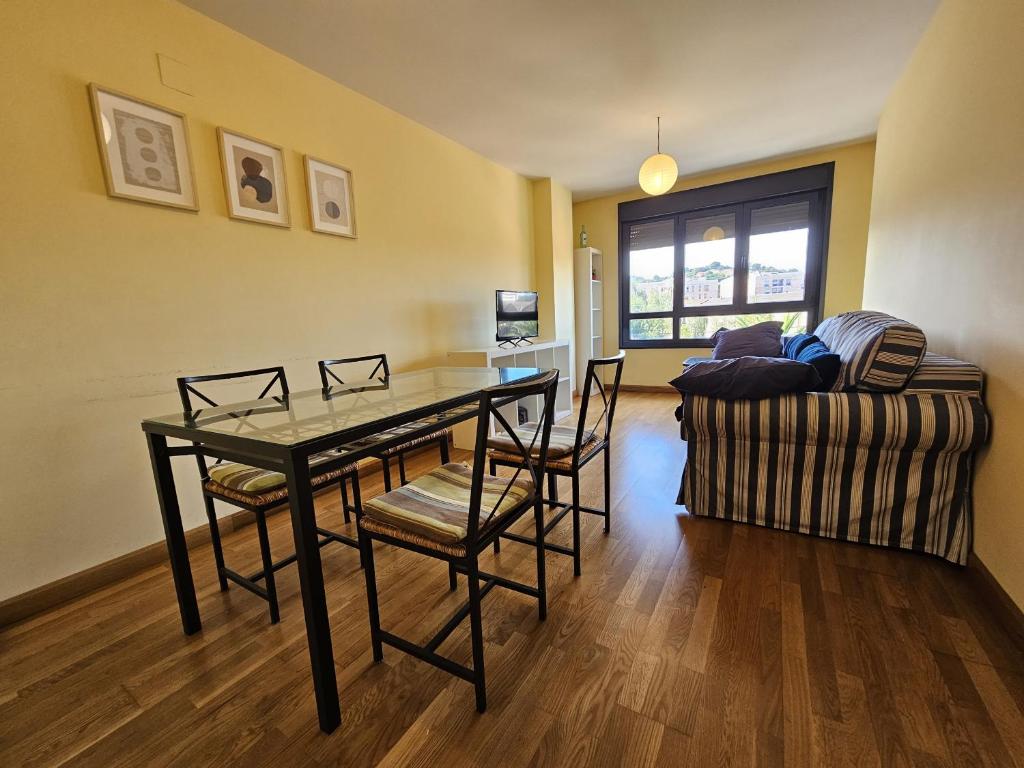 comedor con mesa, sillas y sofá en 1A106 Amplio y cómodo apartamento, en Gijón