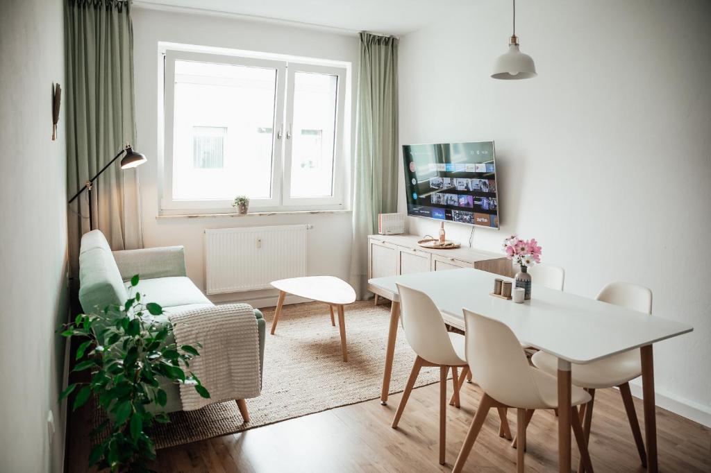 a living room with a white table and chairs at 2 Bdr zentral SmartTV hell & gemütlich in Wilhelmshaven