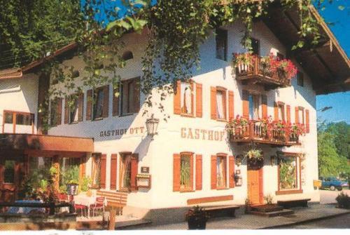 a large white building with flowers on the balconies at Gasthof Zum Ott in Staudach-Egerndach